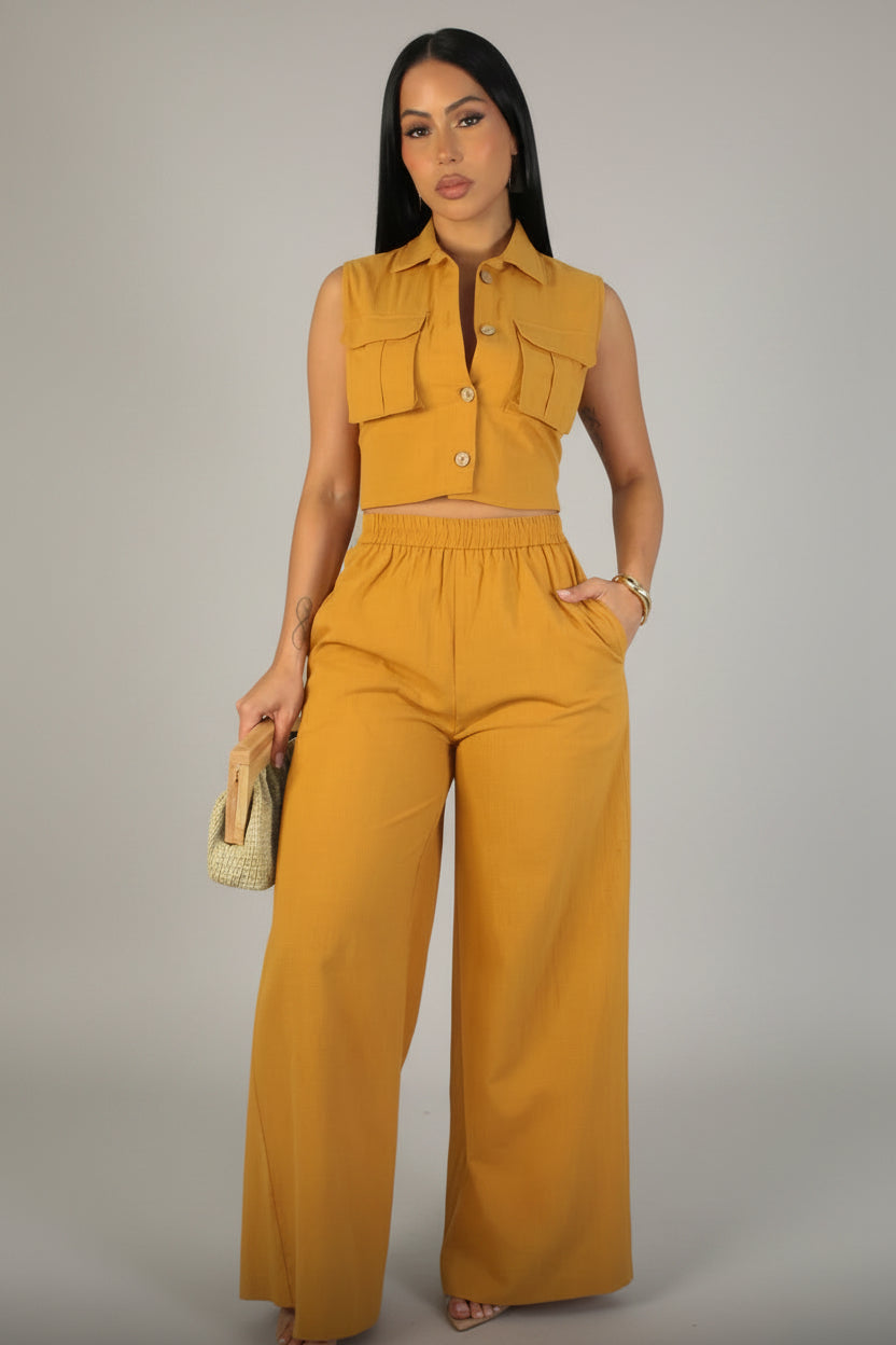 Woman wearing a mustard yellow outfit on a plain background model is wearing small